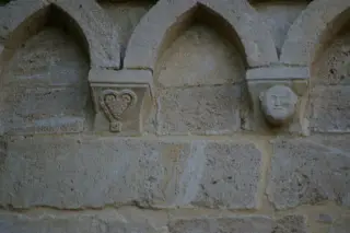 Fregi esterni: figura antropomorfa e grappolo d'uva - Pieve o Chiesa Cimiteriale di San Lorenzo a Montiglio Monferrato