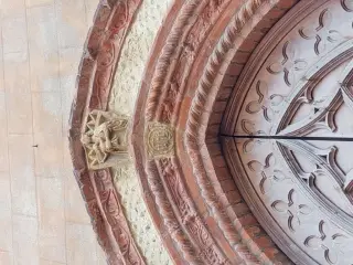 Madonna col Bmbino e scritta IHS sul portale - Oratorio di San Bartolomeo a Valenza