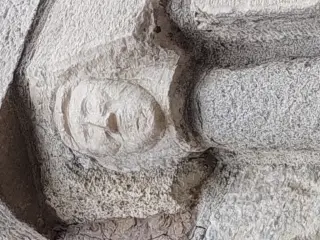Portale dettaglio volto scolpito - Parrocchiale di San Massimo a Isasca